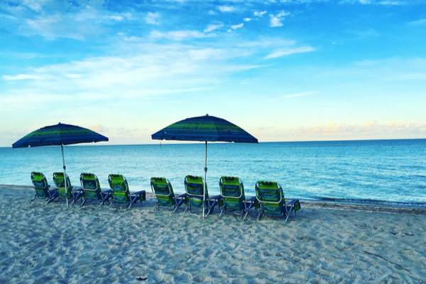 Group of beach chairs and umbrellas lined up along the shore of the beach in Captiva Island, FL
